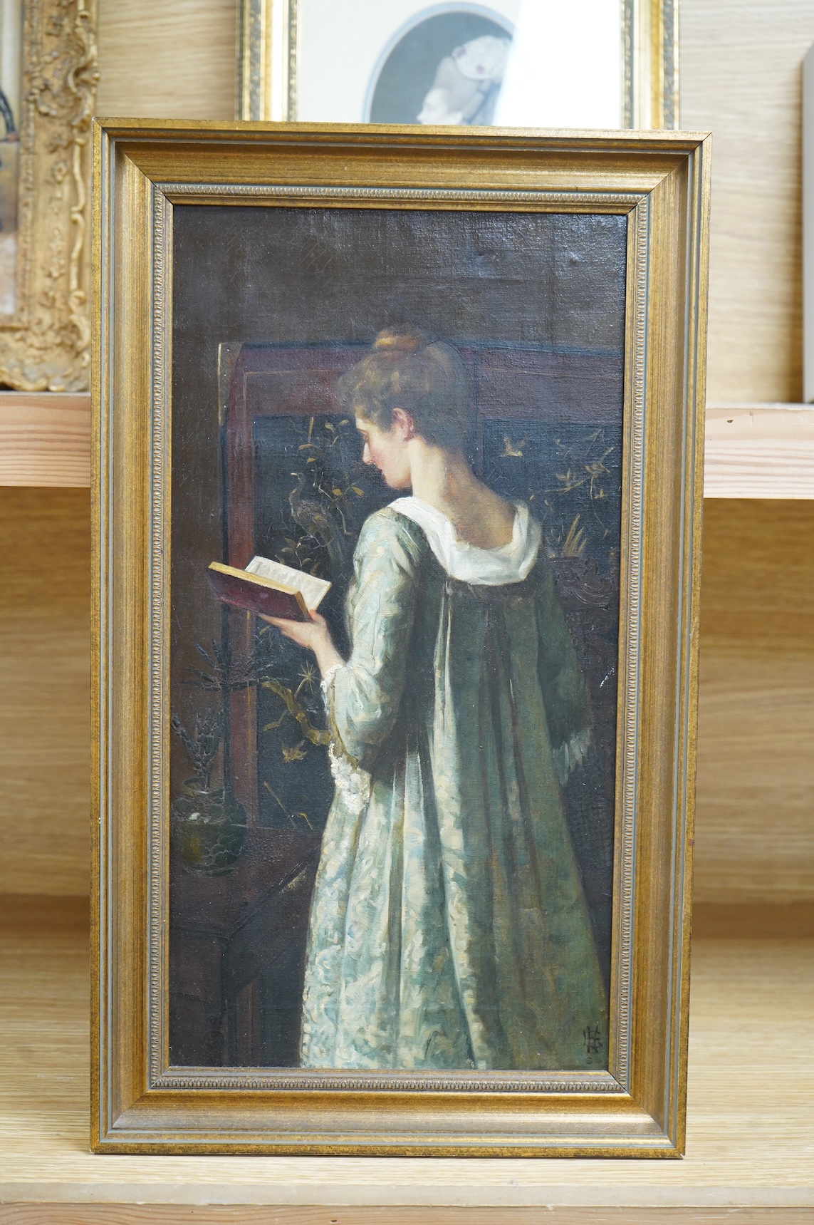 Pre-Raphaelite school, Three quarter length portrait of a lady reading, monogrammed lower right, FHL?, oil on canvas, 41 x 21cm